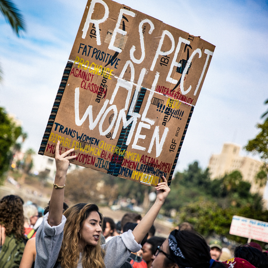 Frau hält Schil mit Aufschrift "Respect all Women"